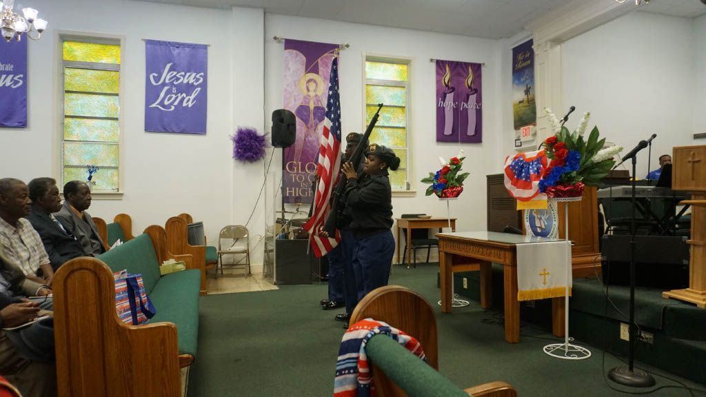 A woman is holding an american flag in a church.