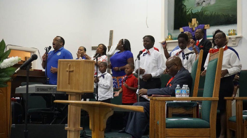 A group of people are singing in a church.