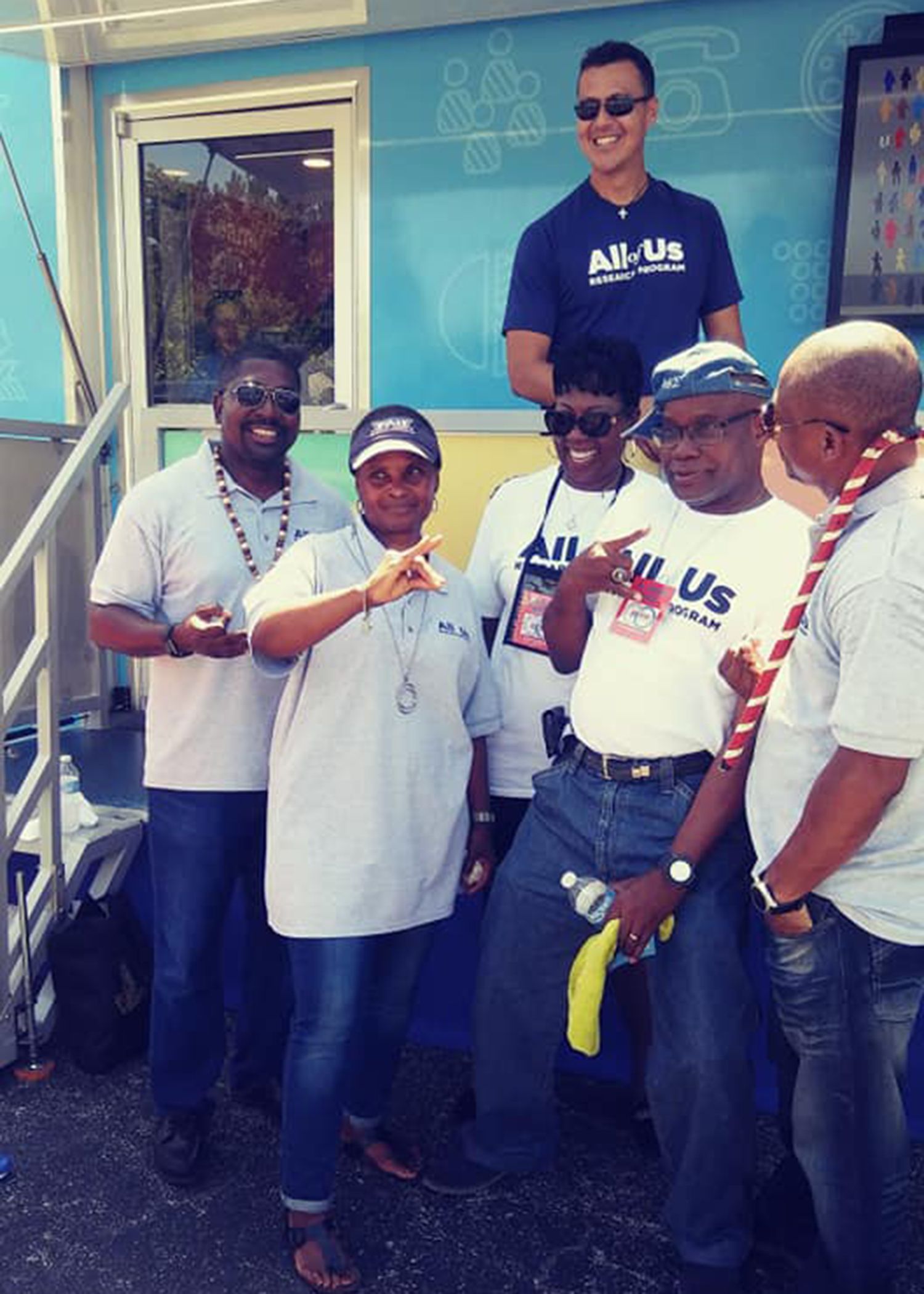 A group of people wearing shirts that say all us are posing for a picture