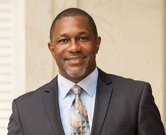 A man in a suit and tie is smiling for the camera.