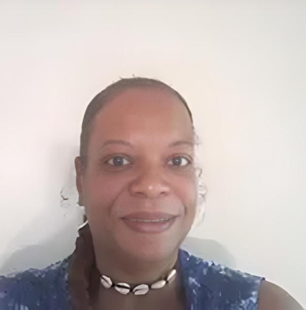 A woman wearing a blue shirt and a choker is smiling for the camera.