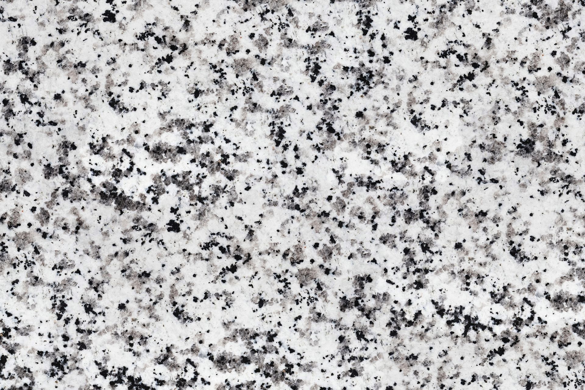 Close-up of speckled white granite with black and gray flecks.