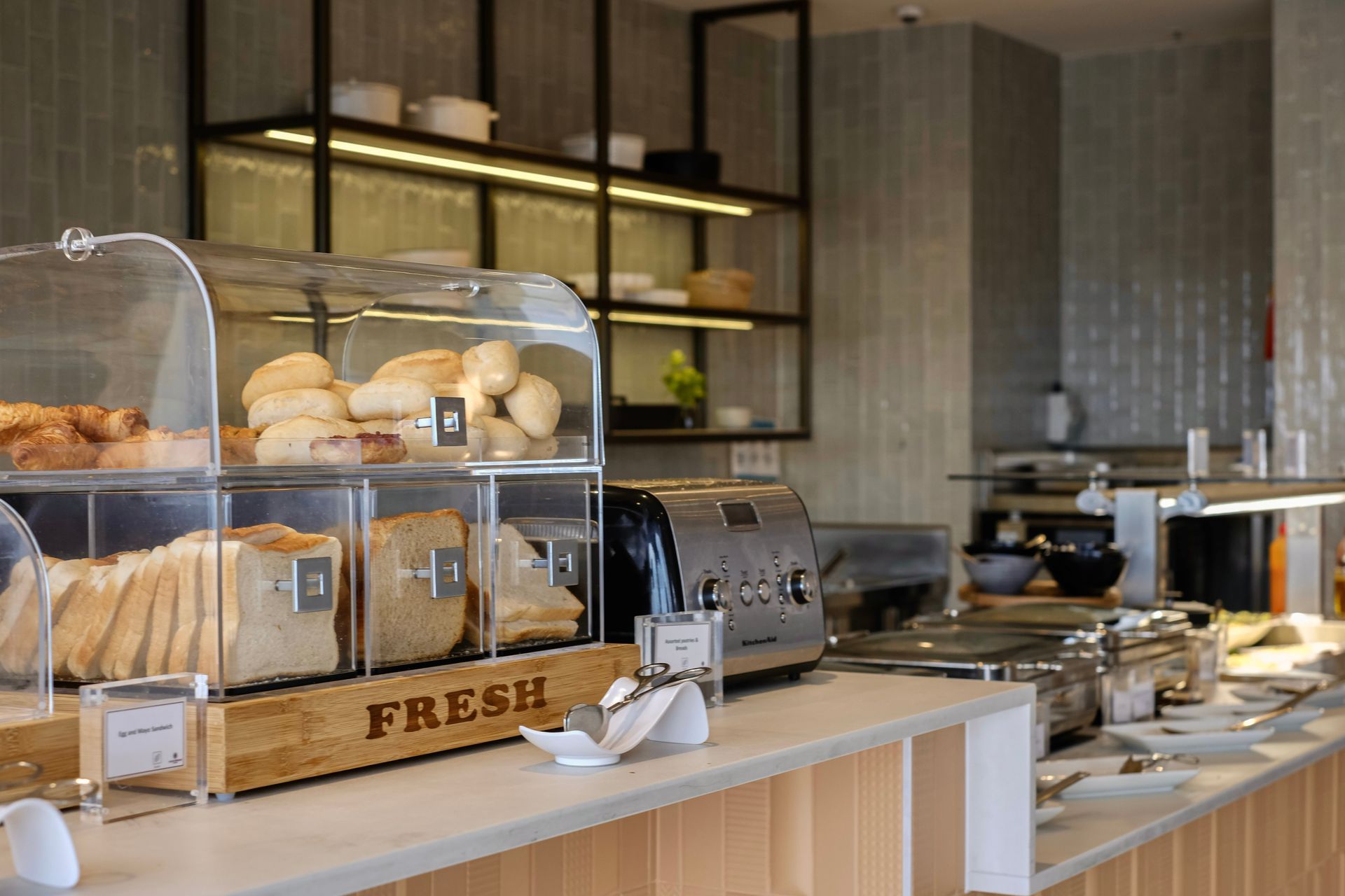 Bakery counter with pastries in glass cases and shelves in a modern café interior