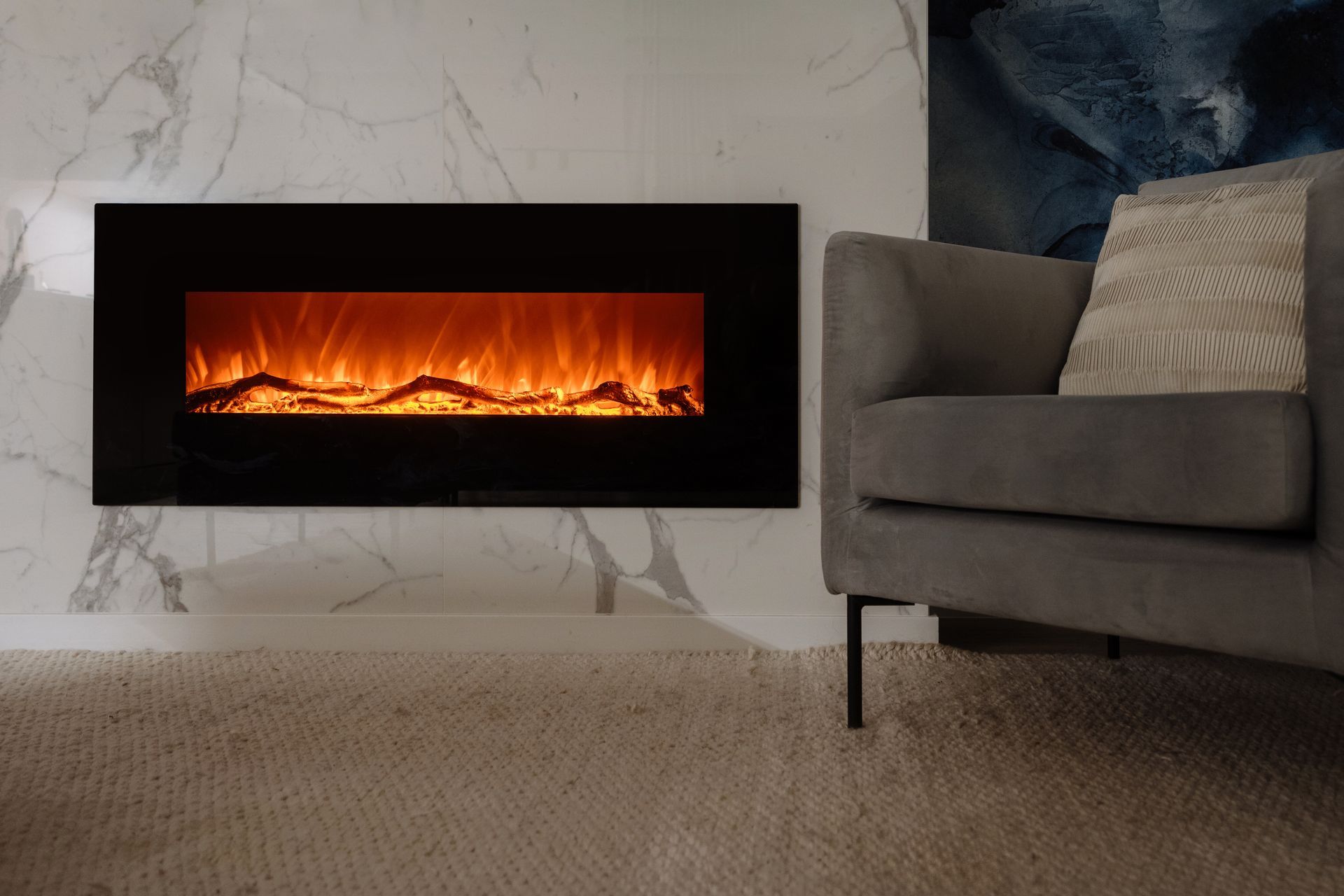 Modern living room with stone fireplace, large TV, gray sofas, and a white coffee table
