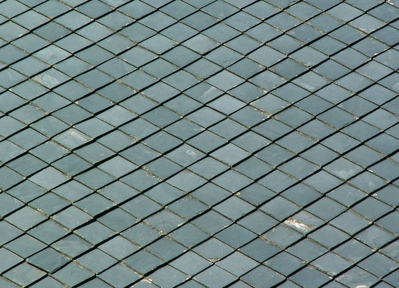 Overhead view of a rooftop covered in diamond-shaped, gray slate tiles.