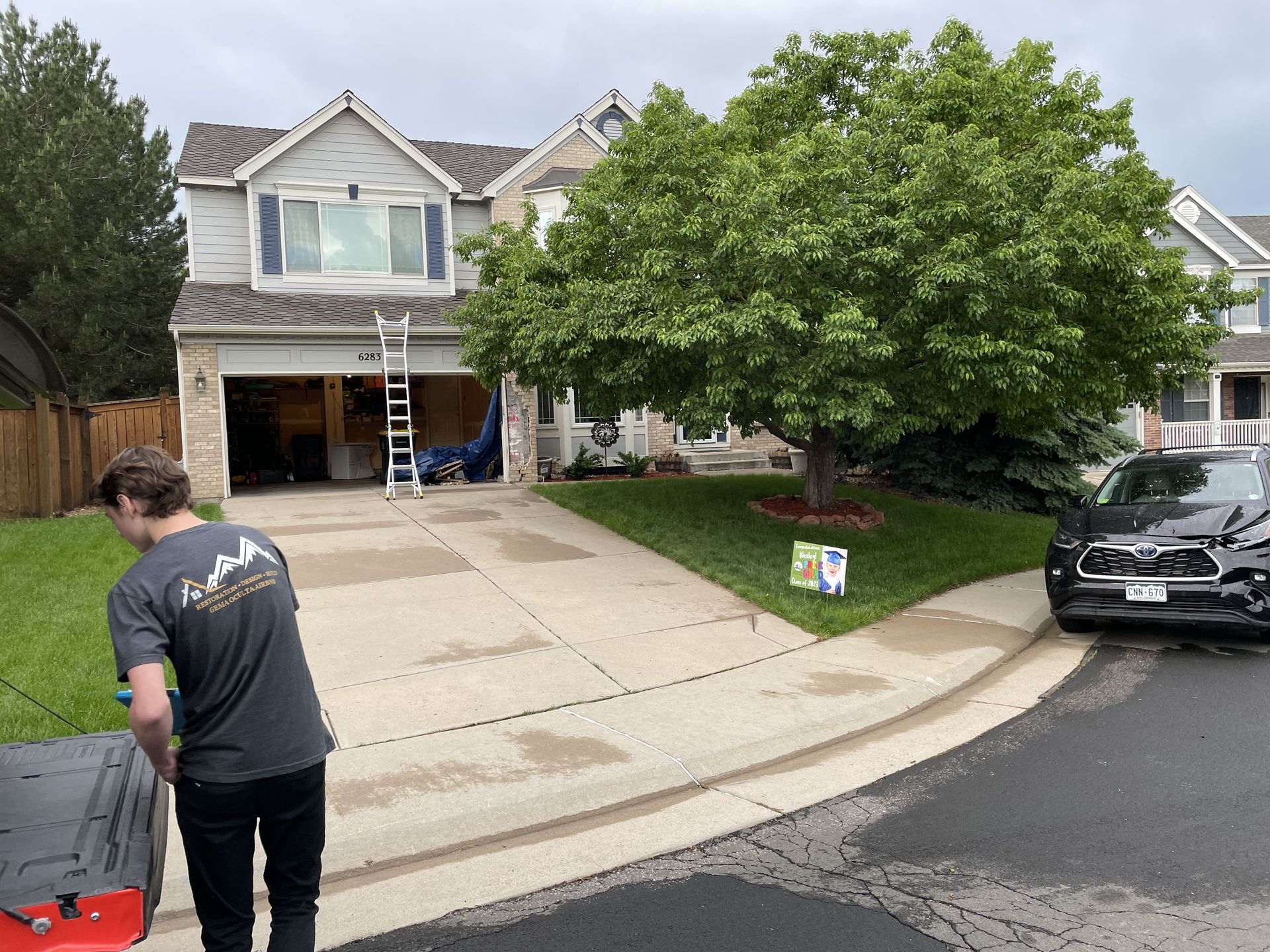 A person stands near a driveway, w