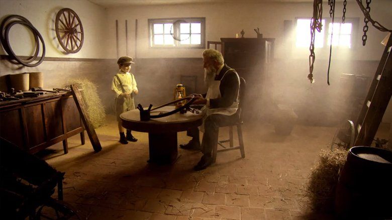 Um homem e um menino estão sentados à mesa de uma sala.