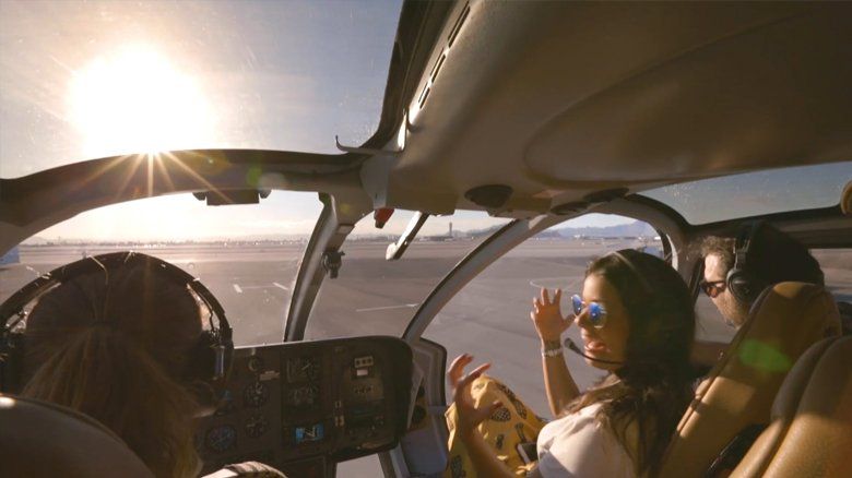 Uma mulher está sentada na cabine de um helicóptero.