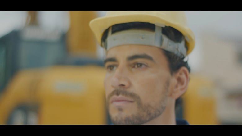 Um close de um trabalhador da construção civil usando um capacete.