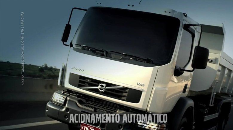 Um caminhão Volvo branco está estacionado na beira da estrada.