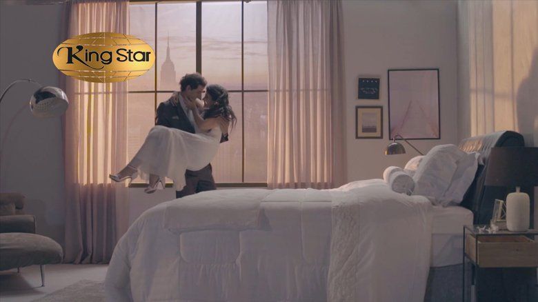 Um homem está segurando uma mulher nos braços em um quarto.