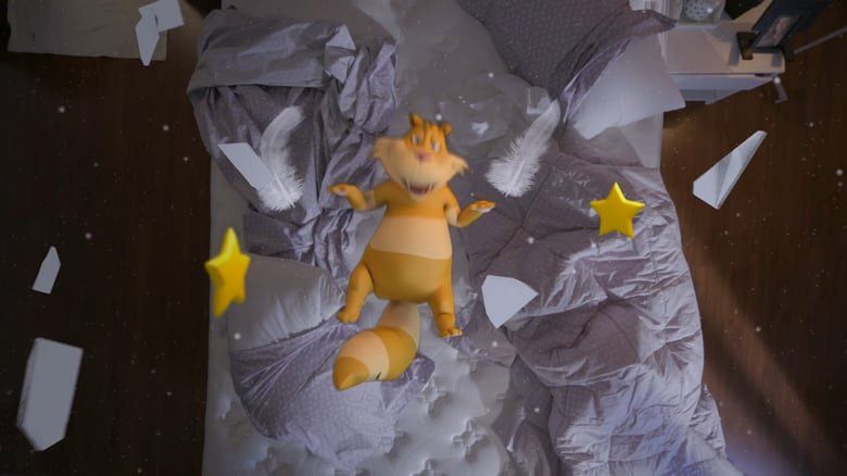 Um bicho de pelúcia está deitado em cima de uma cama rodeado de papéis e estrelas.