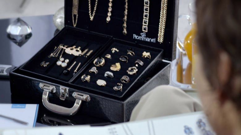 Uma mulher está olhando para uma pasta cheia de joias