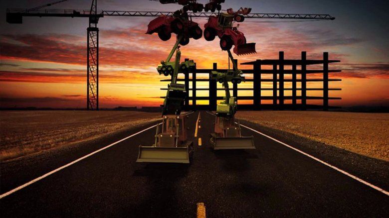 Dois tratores estão dirigindo por uma estrada com um guindaste ao fundo.