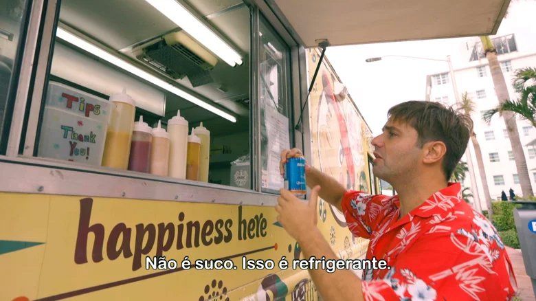 Um homem está parado na frente de um food truck que diz felicidade aqui