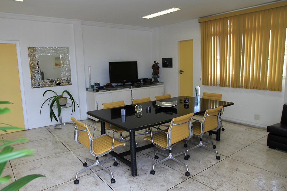 Uma sala de conferências com mesa e cadeiras e uma televisão