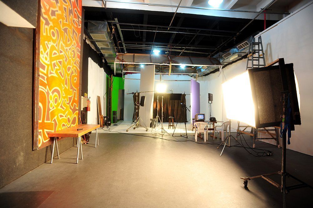 Uma grande sala vazia com uma tela verde na parede