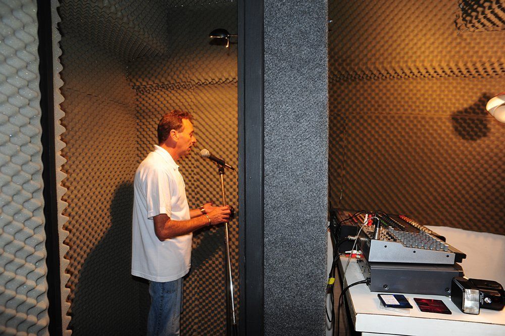 Um homem de camisa branca está cantando em um microfone