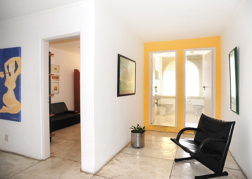 Uma sala de espera com um banco e uma pintura na parede