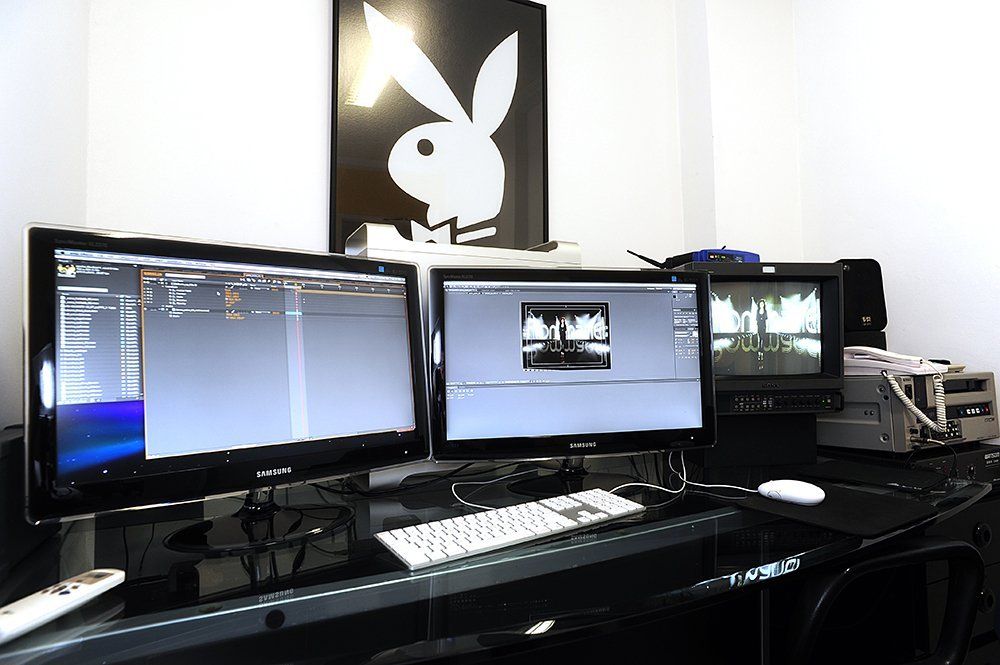 Um pôster da coelhinha da playboy pendurado acima da mesa do computador