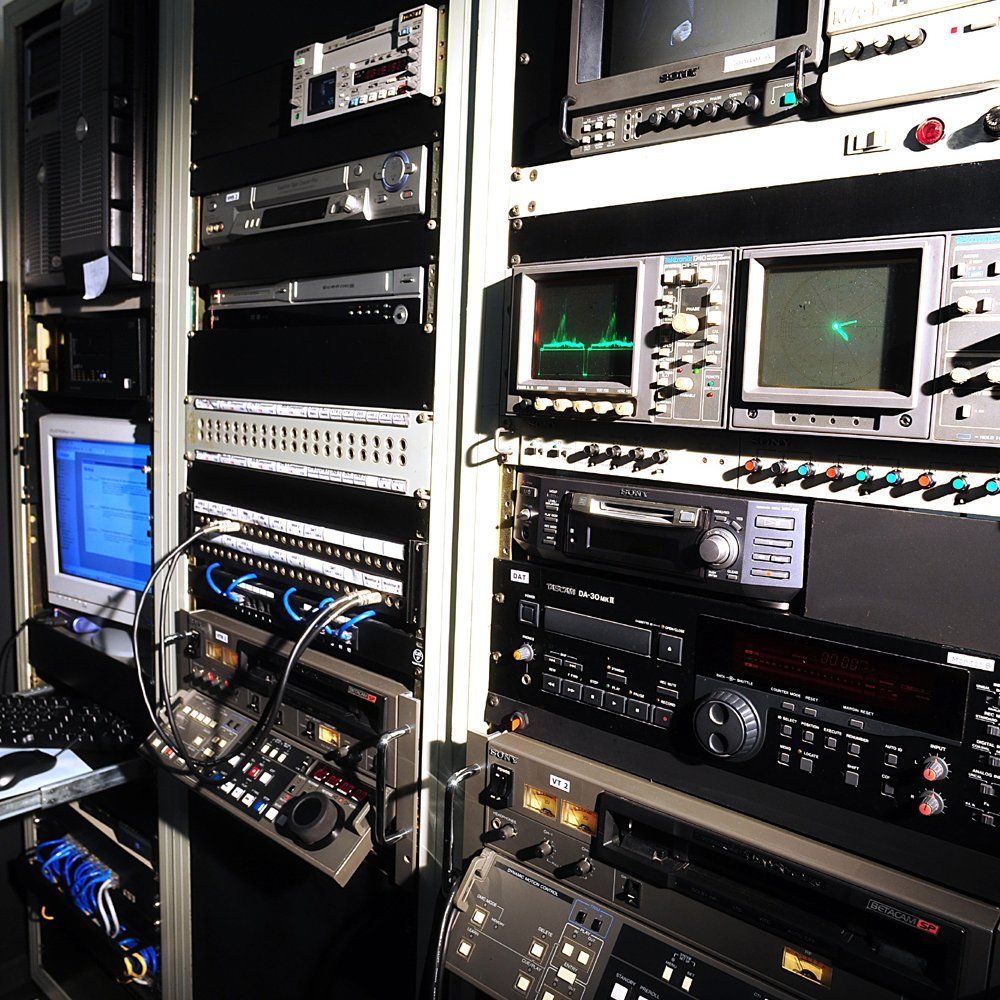 Um monte de eletrônicos estão empilhados uns sobre os outros, incluindo um que diz 'lg'