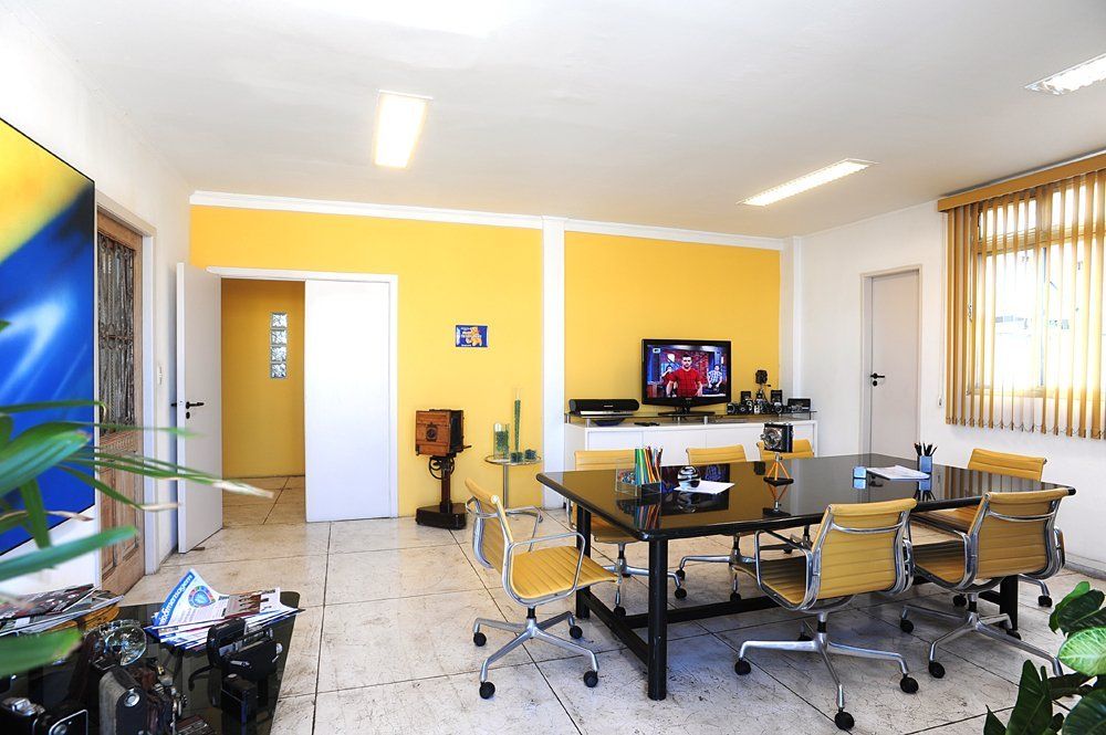 Uma sala de conferências com mesa e cadeiras e uma televisão