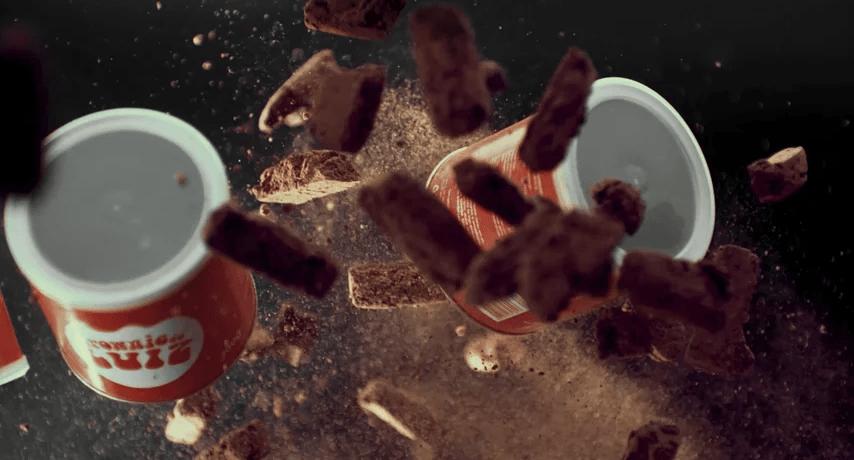 Duas xícaras de chocolate quente estão sendo esmagadas por pedaços de chocolate.