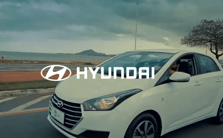 Um carro Hyundai branco está estacionado na beira da estrada.