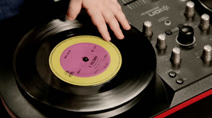 Uma pessoa está tocando um disco em um toca-discos.