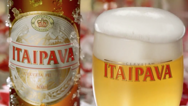 Uma garrafa de cerveja itaipava ao lado de um copo de cerveja