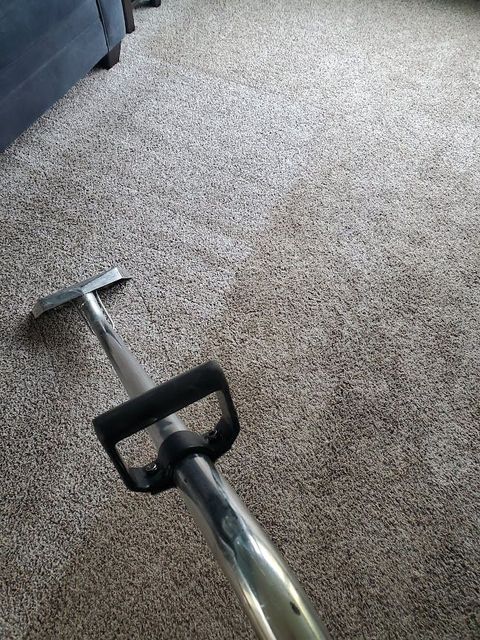 Strongarm Cleaners - A vacuum cleaner is cleaning a carpet in a living room.