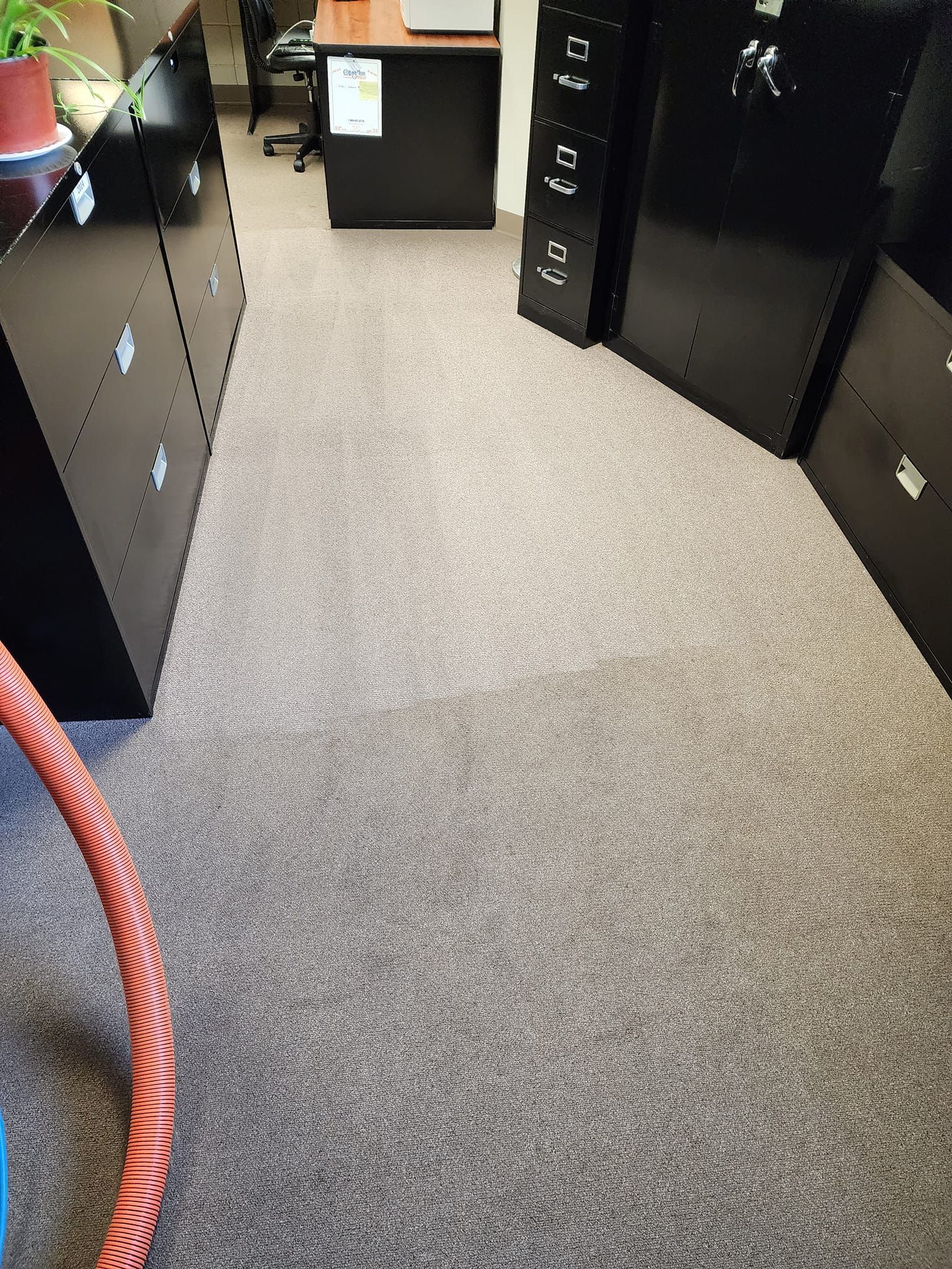 Strongarm Cleaners - A room with a carpeted floor and a vacuum hose in it.