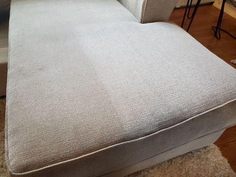 Strongarms Cleaners - A white couch is sitting on a rug in a living room.