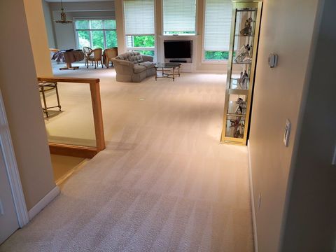 Strongarm Cleaners - A living room with a carpeted floor and a staircase leading to the second floor.