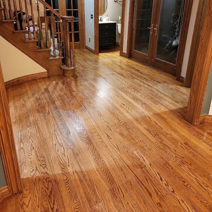 Strongarm Cleaners - A hallway with hardwood floors and stairs in a house