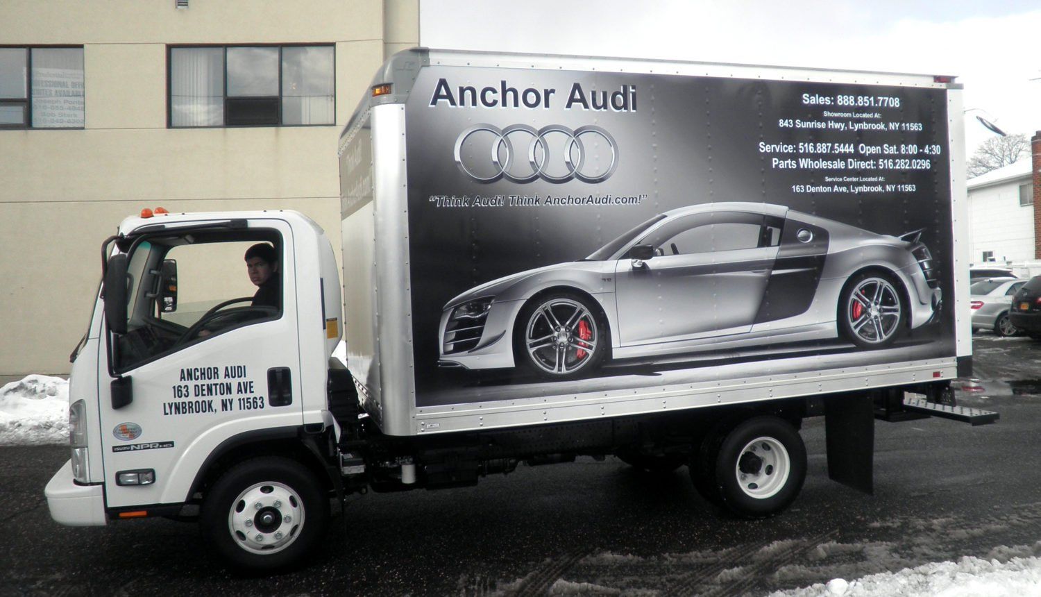 An audi truck is parked in front of a building