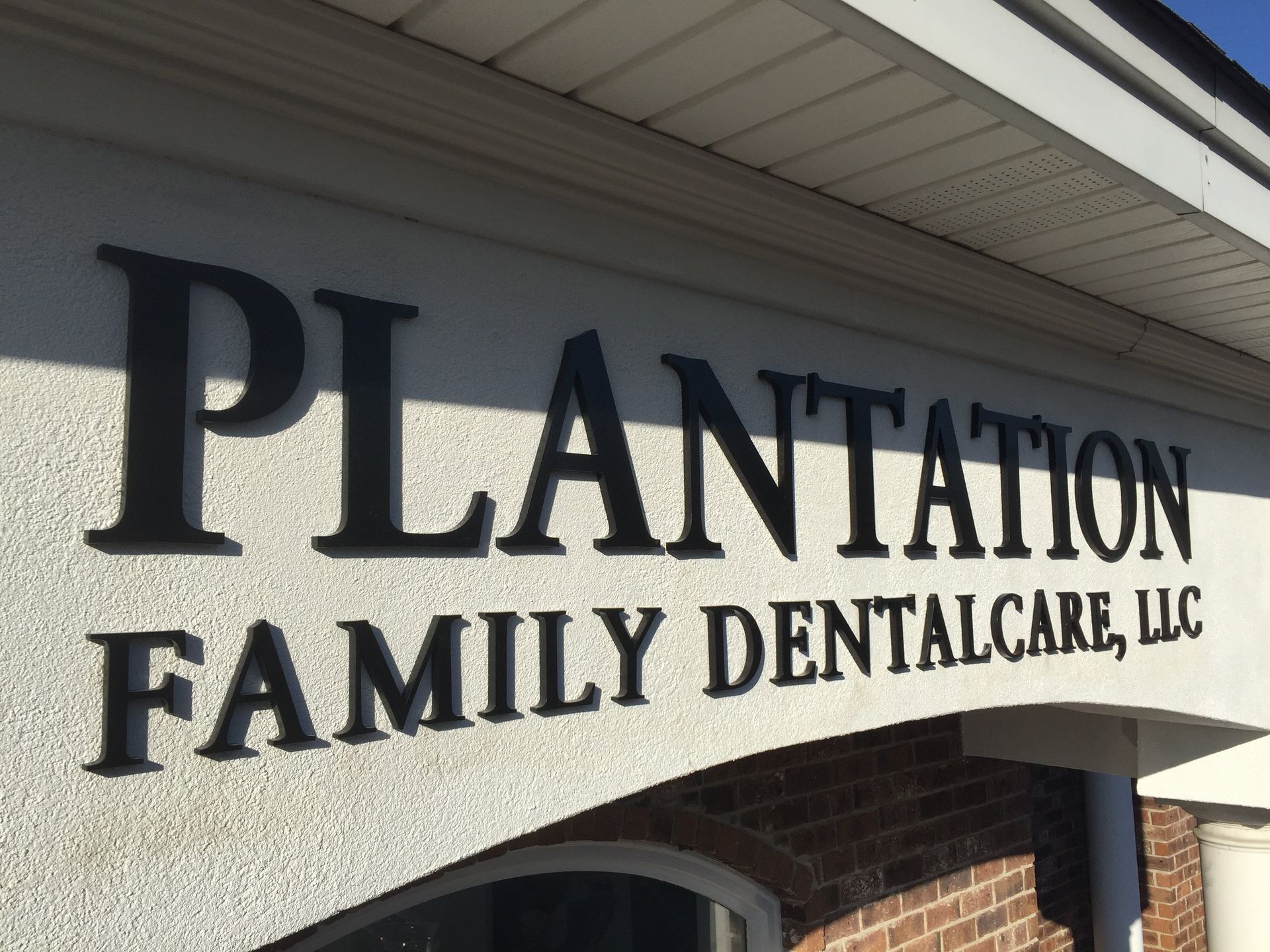 Plantation family dental care llc sign on a brick building