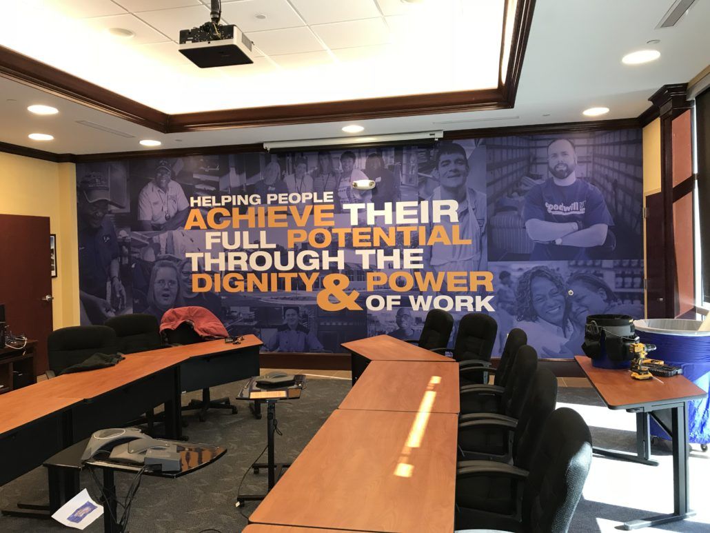 A conference room with a wall that says achieve their full potential through the dignity and power of work