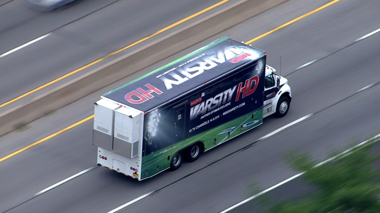 An aerial view of a truck driving down a highway.