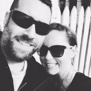 A man and a woman wearing sunglasses are posing for a picture.