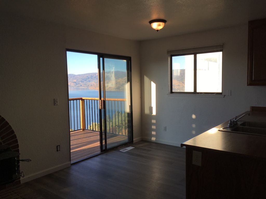 Kitchen with sliding glass door to a deck overlooking a lake, and a window.