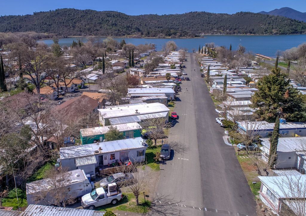 Kitchen with white cabinets, stainless steel appliances, skylight, and wooden floors.