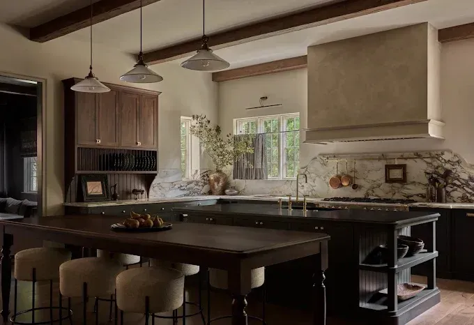 A kitchen with a large island , a table and stools.