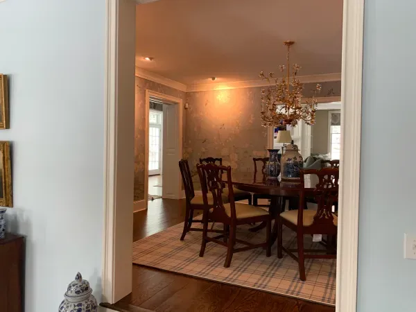 A dining room with a table and chairs and a chandelier.