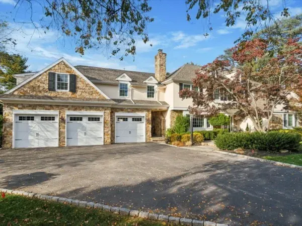 A large house with three garage doors and a driveway.