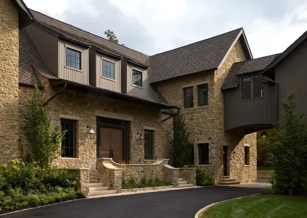 A large house with a lot of windows and a driveway leading to it.