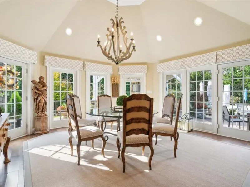 A dining room with a table and chairs and a chandelier