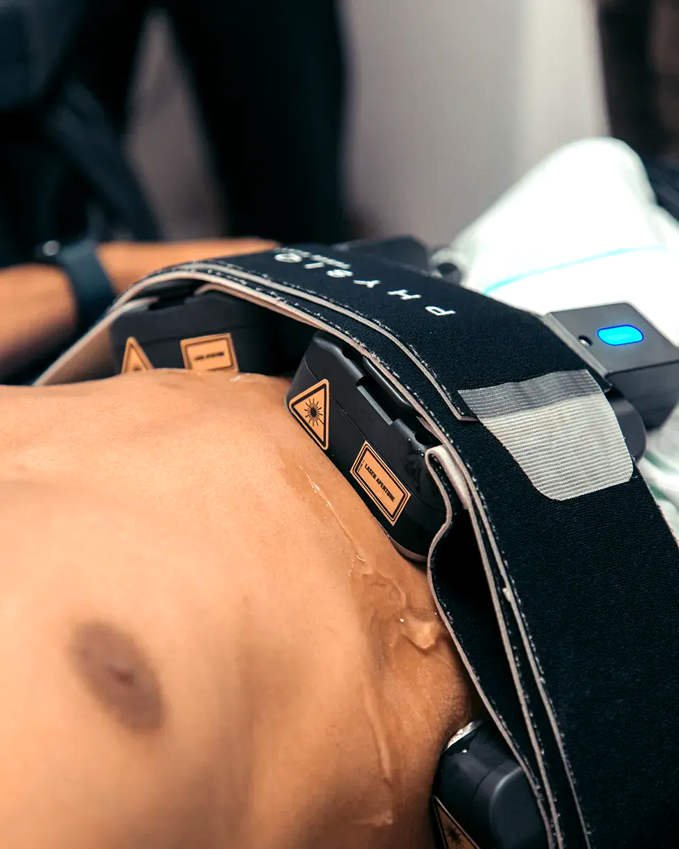 A person with a black strap around their torso with devices attached.