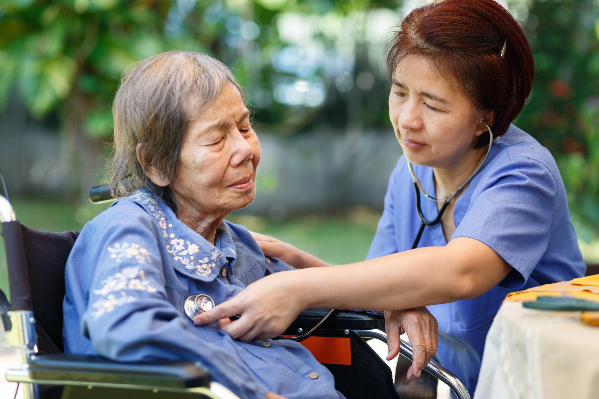 Healthcare worker providing compassionate care to an elderly woman in a wheelchair