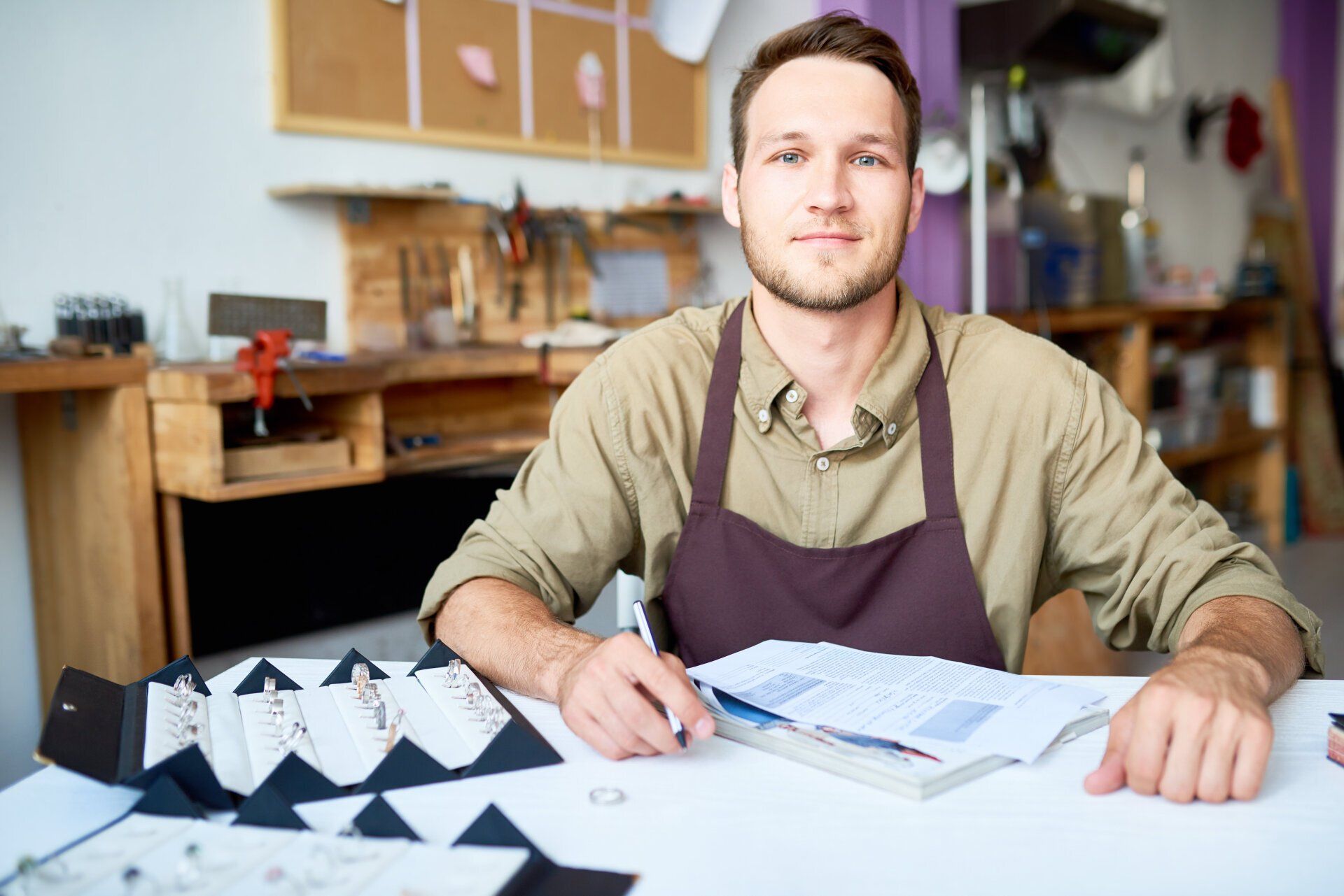 Small business owner crafting jewelry at a workstation in a creative studio